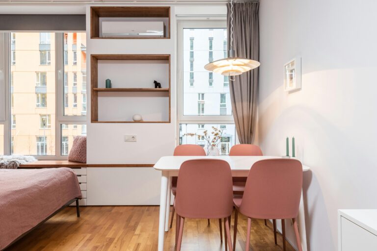 A cozy modern apartment interior with minimalist design and pink accents.