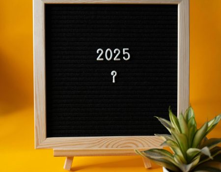pexels-photo-29996963-29996963 Black letter board displaying '2025' on yellow background with a succulent plant.